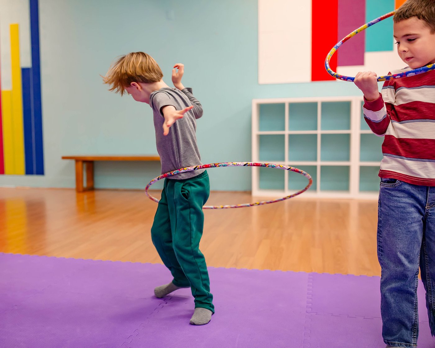 Two older kids playing an active rhythm game with hoops